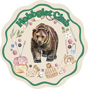 Hobbyist Club logo - realistic walking bear illustration in badge surrounded by yarn, buttons, pins, and other craft items with text, 'Hobbyist Club'