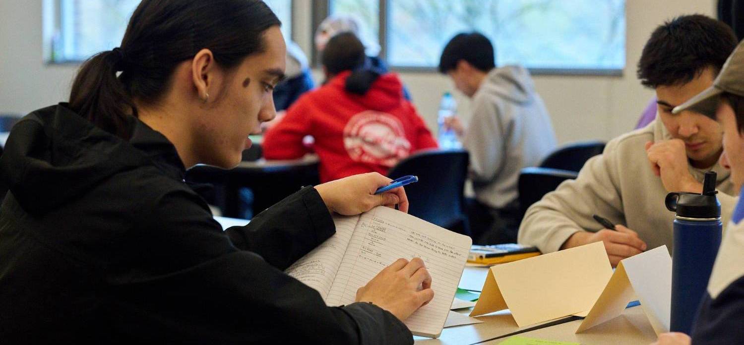 A student reading in front of a computer, demonstrating a focused and studious approach to online learning or research.