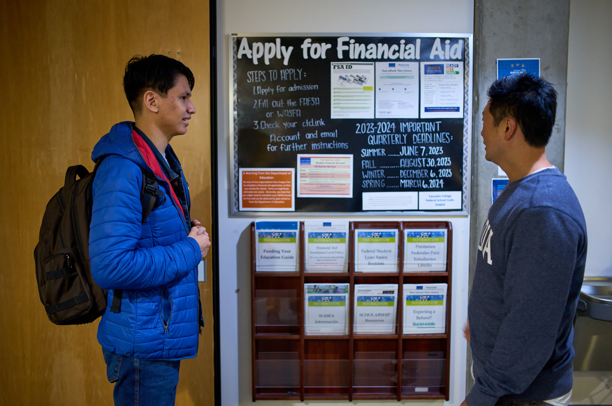 A student engaged in conversation with an advisor, discussing financial aid and seeking guidance.