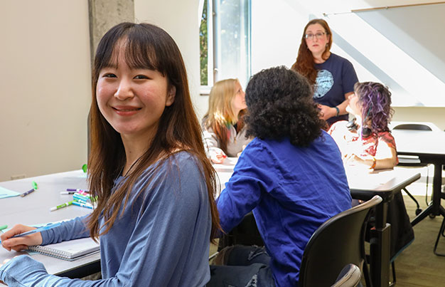 Smiling student inside a classroom environment.