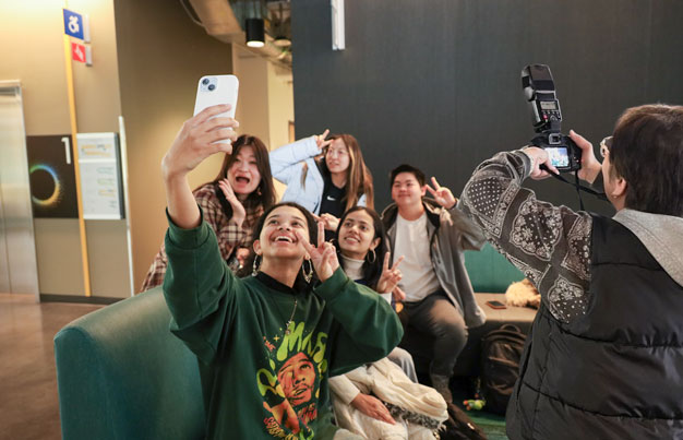 Student taking selfie in a photoshoot.