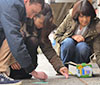 three students doing chalk art in downtown Bothell