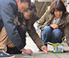 three students doing chalk art in downtown Bothell