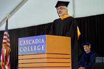 Cascadia faculty making the keynote speech at a podium on stage at the ceremony