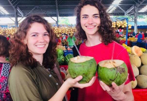two girls holding coconut 